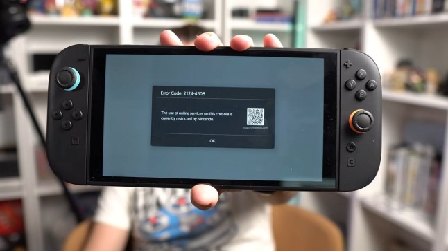 Nintendo Switch 2 held in someone's hand while displaying an error message